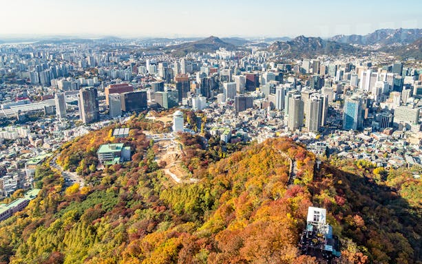 Aerial view of Namsan Mountain and Seoul cityscape with cable car station.