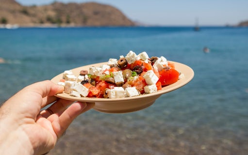 Dakos salad with feta and olives held by the sea on Ithaca island, Greece.