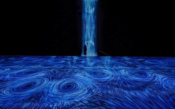 teamLab Planets Tokyo, blue light vortices installation with person standing in the flow.