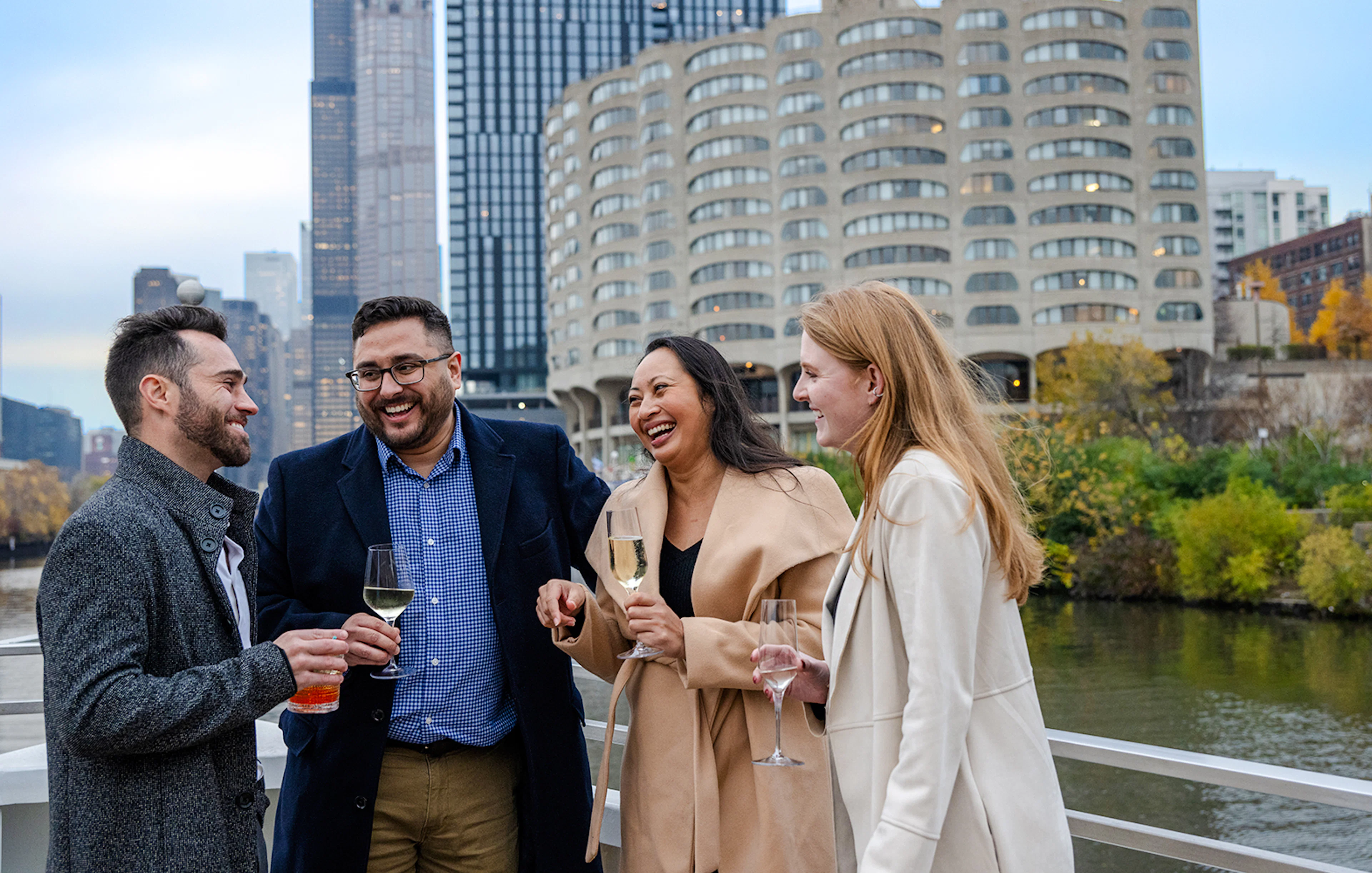 Guests enjoying drinks on a Lake Michigan dinner cruise with Chicago skyline in the background.