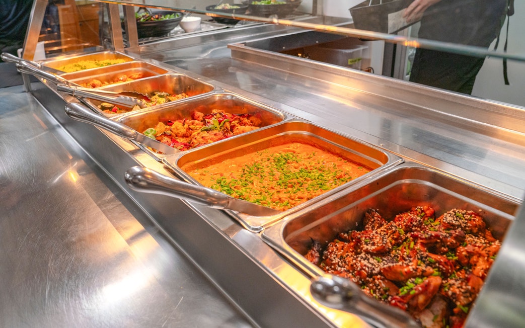 Buffet with curries and roasted vegetables on wilderness cruise.