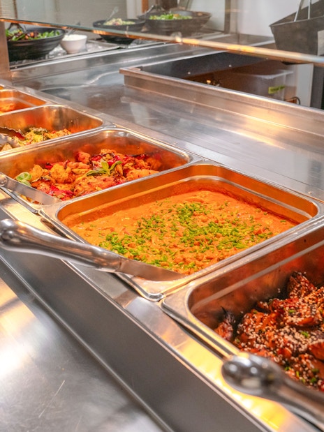 Buffet with curries and roasted vegetables on wilderness cruise.