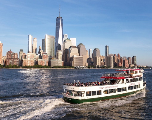 Sightseeing cruise boat on the Hudson River with New York City skyline in the background.