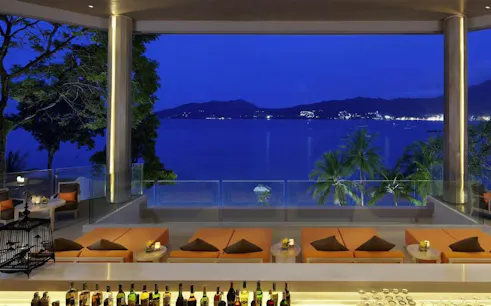 Ocean-view dining area at La Gritta, Amari Phuket, overlooking Patong Bay at night.