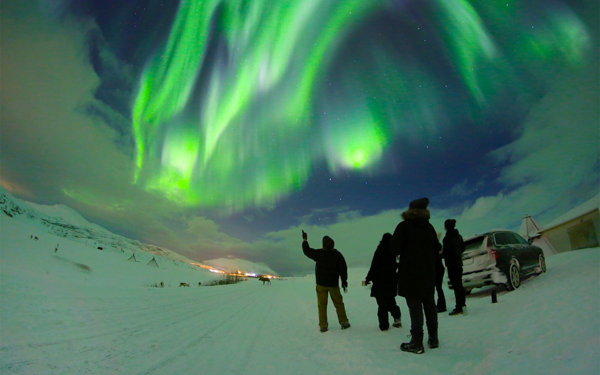 People watching Northern Lights with guide in Tromso, Norway.