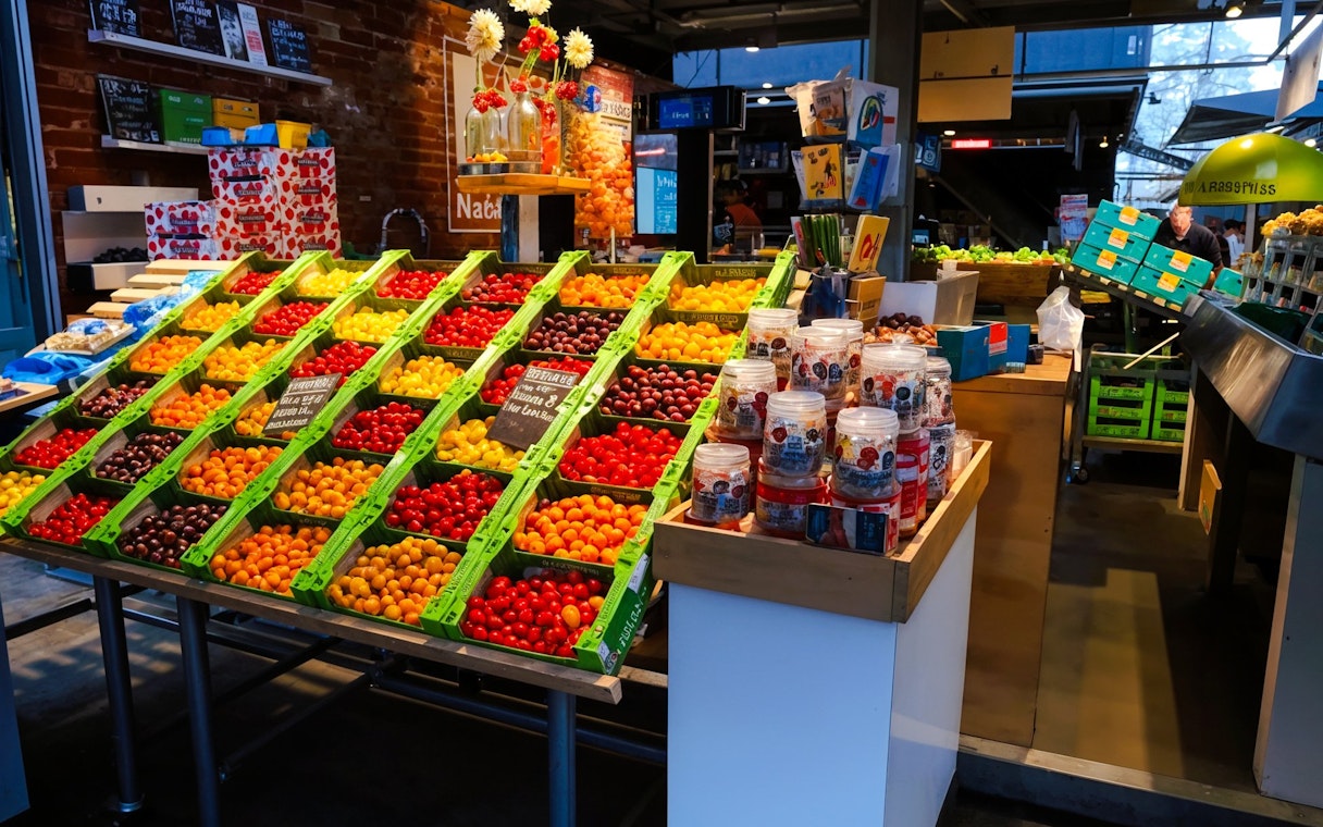 Colorful fruit display at a food stall in the Markthal, Rotterdam.