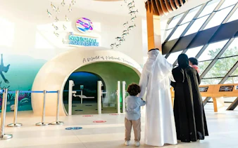 Family entering National Aquarium Abu Dhabi through main entrance.