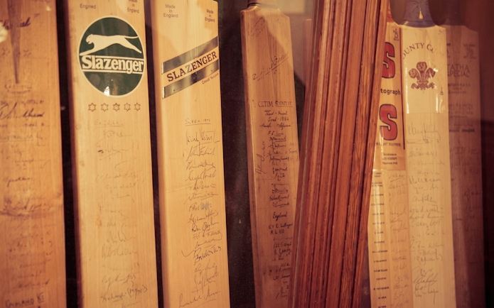 Signed cricket bats displayed at Kia Oval Stadium.
