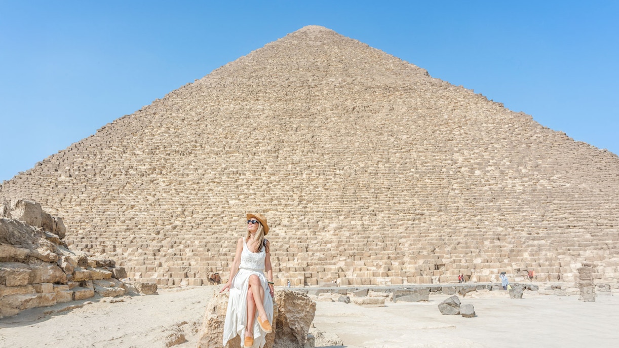 Tourist posing in front of Giza Pyramids, Cairo, Egypt.