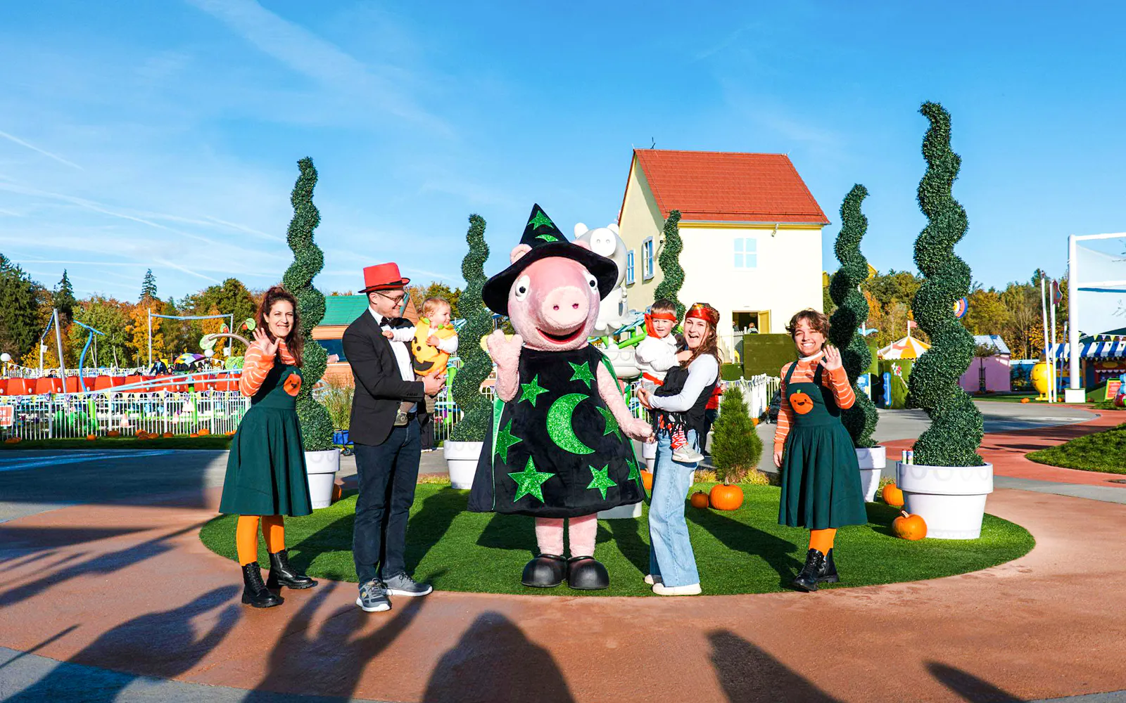 Peppa Pig in a witch costume with families at Halloween event in Peppa Pig Park.