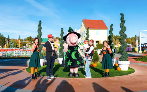 Peppa Pig in a witch costume with families at Halloween event in Peppa Pig Park.