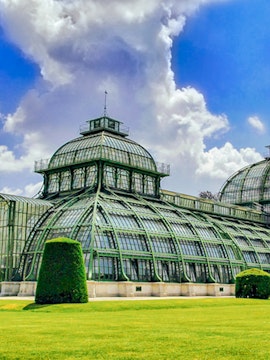 Glass-domed structure with green metal framework near St. Anne's Church, surrounded by manicured lawns.