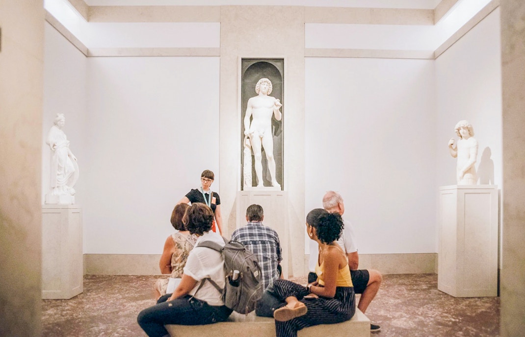 Tourists viewing Greek and Roman statues at the Metropolitan Museum of Art, New York.