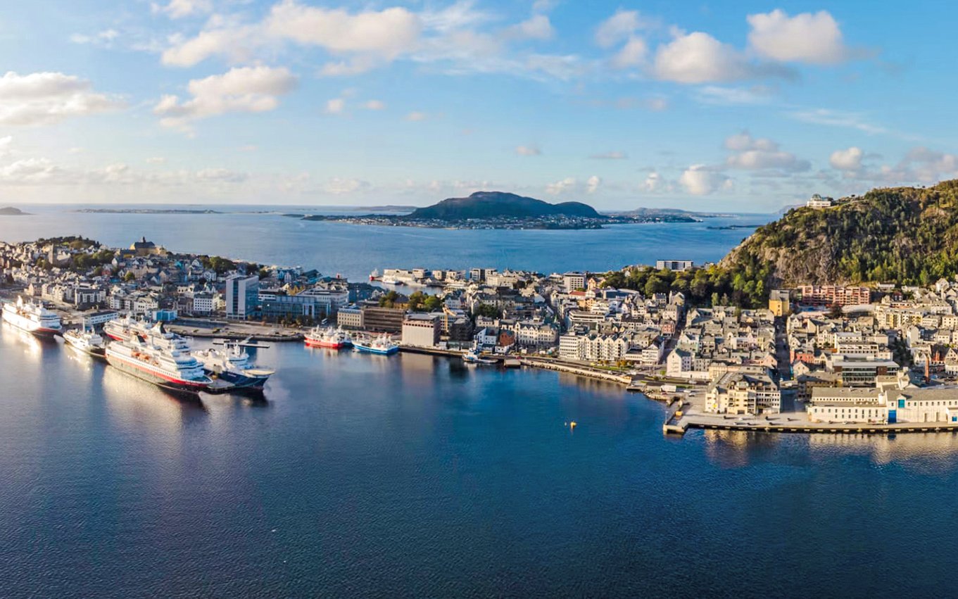 Aerial view of Ålesund port city with cruise ships docked, overlooking Hjørundfjord, Norway.