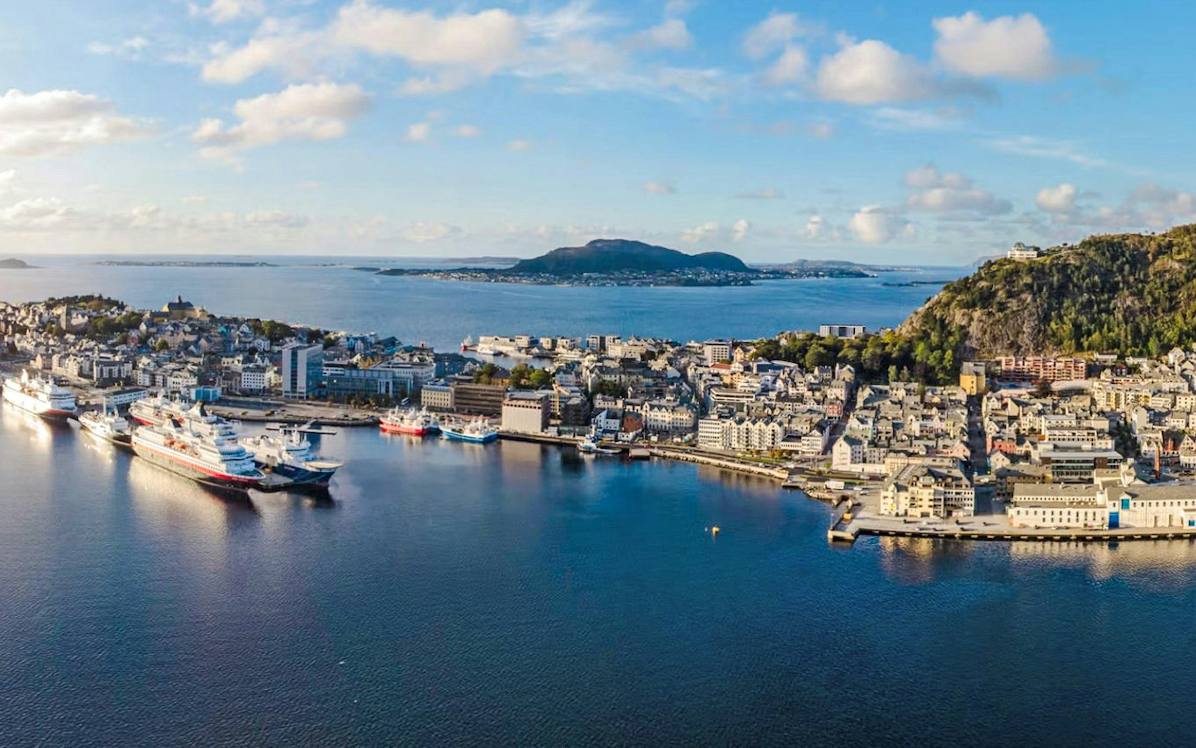 Aerial view of Ålesund port city with cruise ships docked, overlooking Hjørundfjord, Norway.