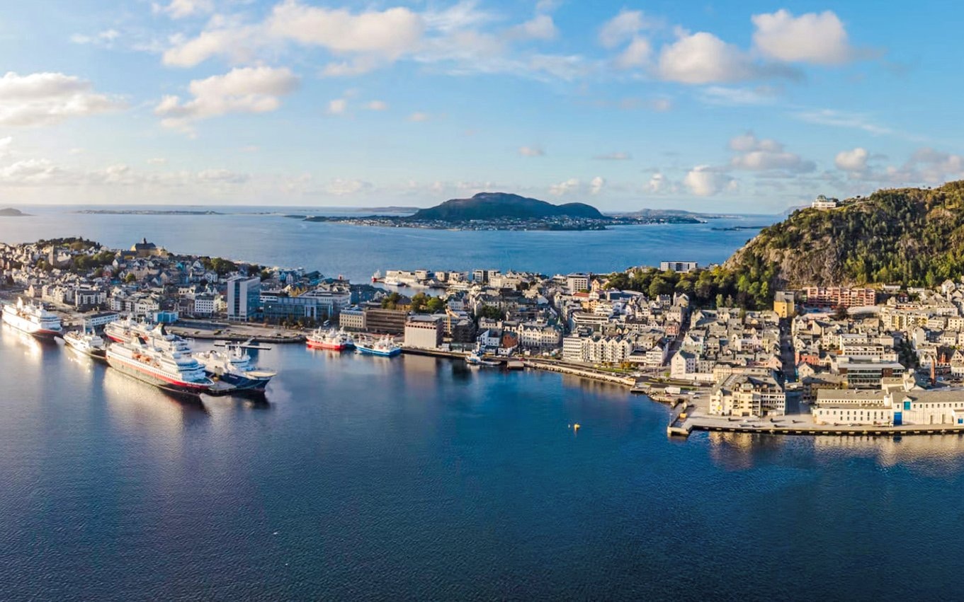 Aerial view of Ålesund port city with cruise ships docked, overlooking Hjørundfjord, Norway.