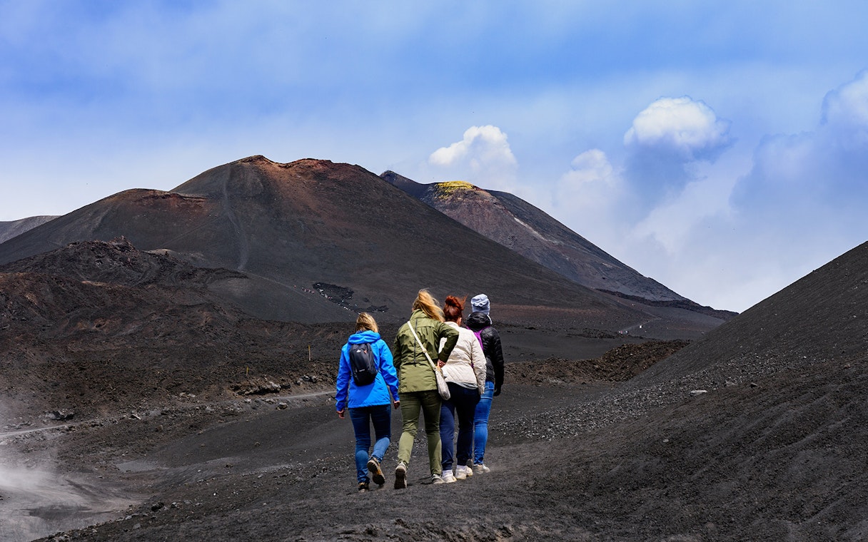 Women hiking towards Mount Etna, Sicily.