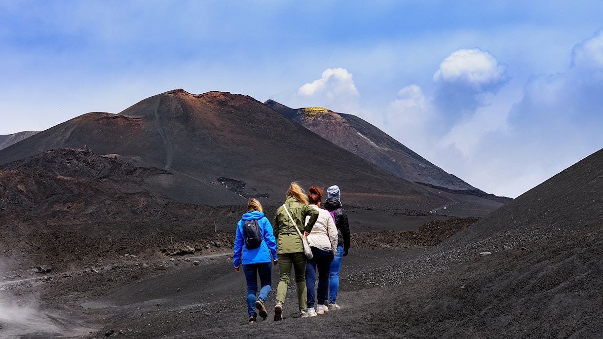 Women hiking towards Mount Etna, Sicily.