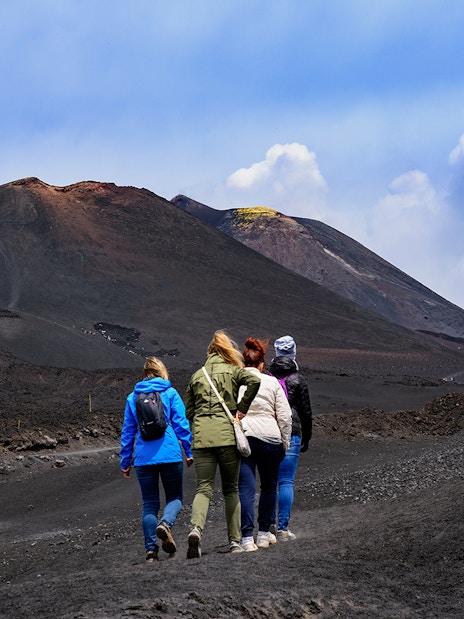 Women hiking towards Mount Etna, Sicily.