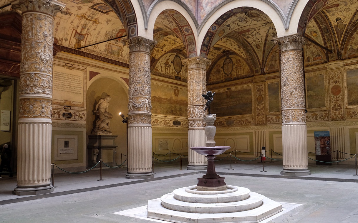 Palazzo Vecchio courtyard with ornate columns and statues in Florence, Italy.