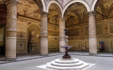 Palazzo Vecchio courtyard with ornate columns and statues in Florence, Italy.