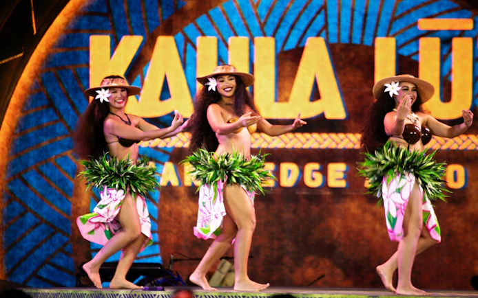 Hula dancers performing at Kaula Luau with traditional attire and floral decorations.