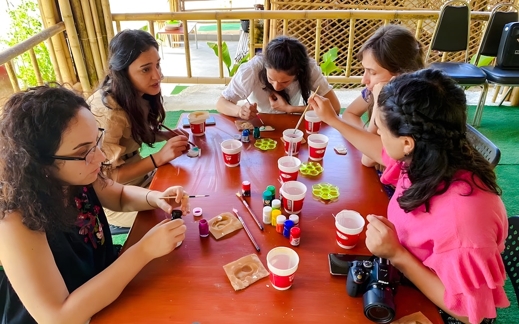 Group painting elephant miniatures at Phuket Elephant Care workshop.