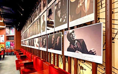 Wall of jazz musician portraits at Reduta Jazz Club interior.