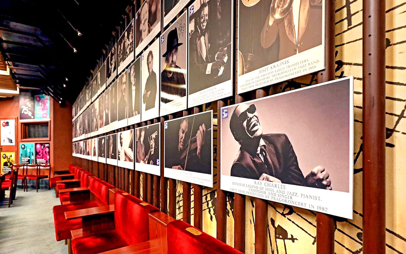 Wall of jazz musician portraits at Reduta Jazz Club interior.