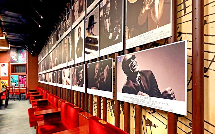 Wall of jazz musician portraits at Reduta Jazz Club interior.