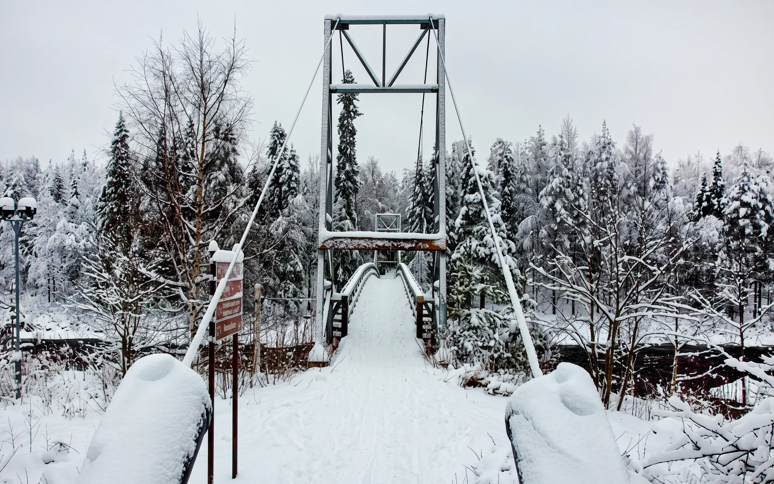 Suspension bridge covered in snow at Vikakongas Nature Reserve, Rovaniemi.