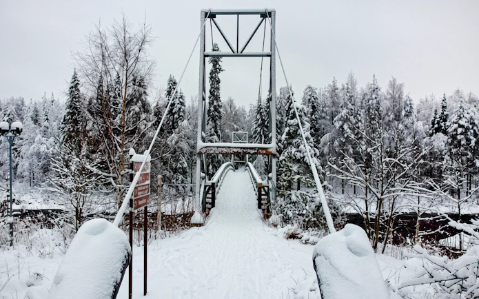 Suspension bridge covered in snow at Vikakongas Nature Reserve, Rovaniemi.