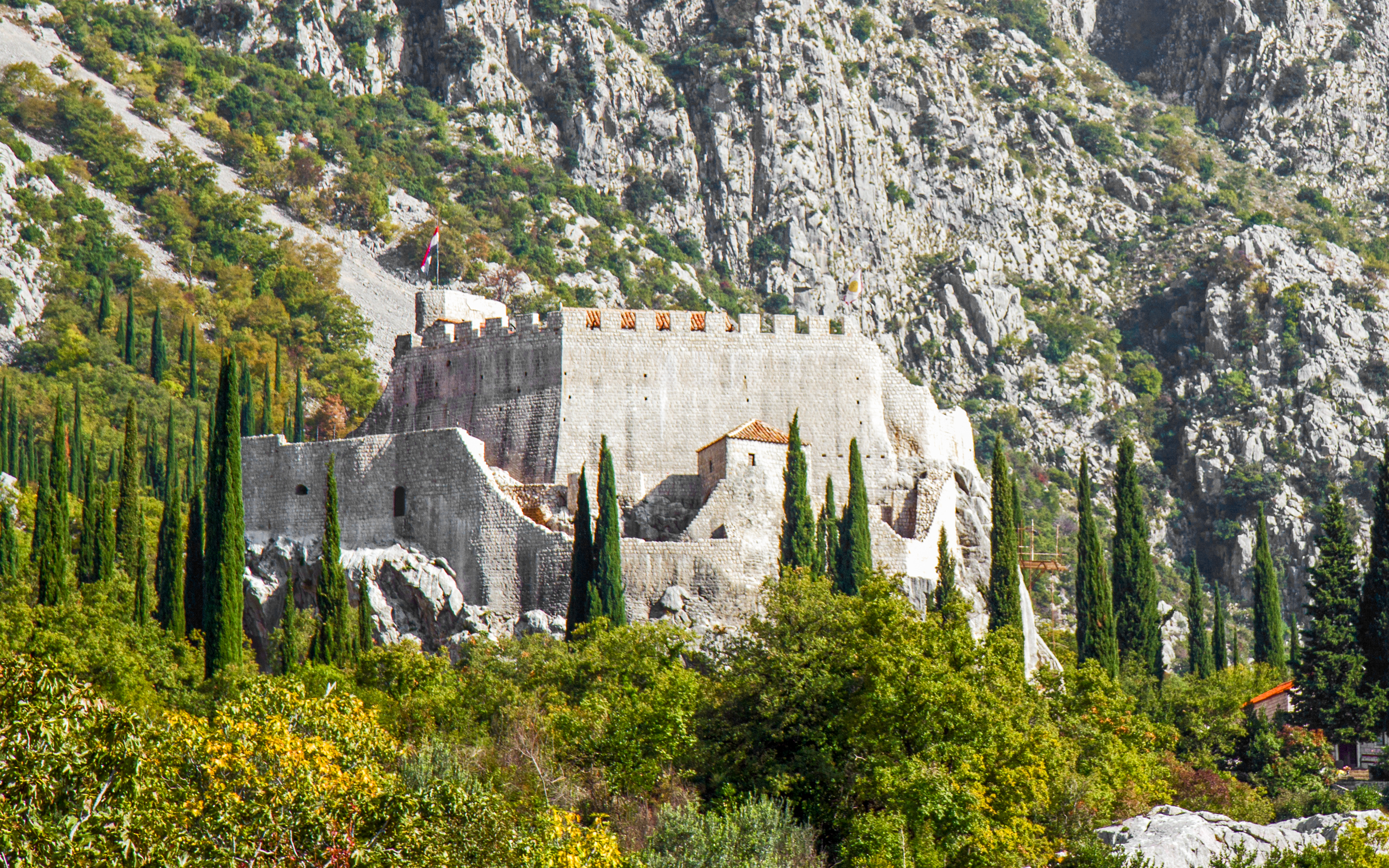 Sokol grad fortress surrounded by trees and rocky hills in Croatia.