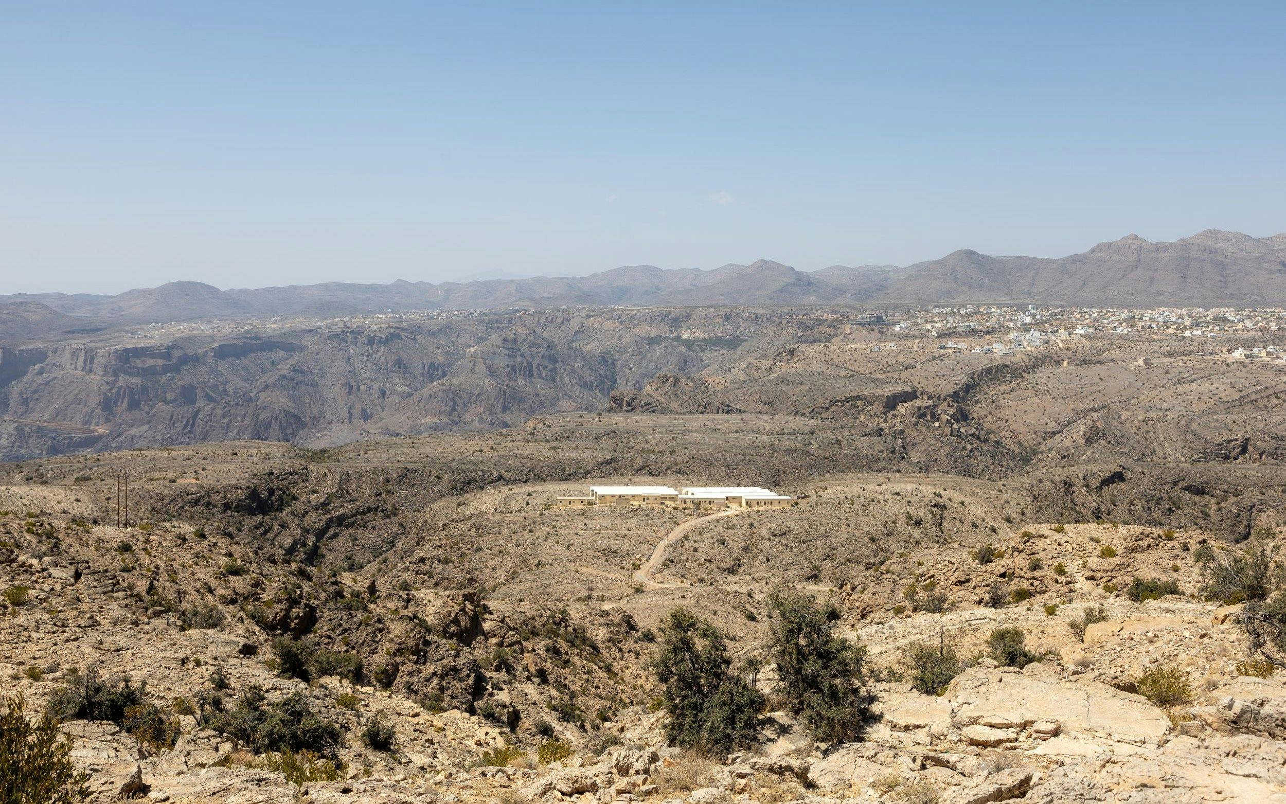 Jebel Akhdar landscape with distant village and rugged terrain, Muscat.