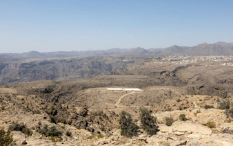 Jebel Akhdar landscape with distant village and rugged terrain, Muscat.