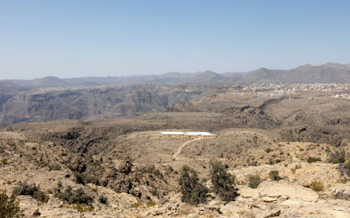 Jebel Akhdar landscape with distant village and rugged terrain, Muscat.