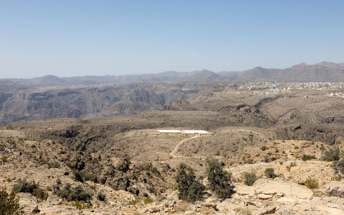 Jebel Akhdar landscape with distant village and rugged terrain, Muscat.