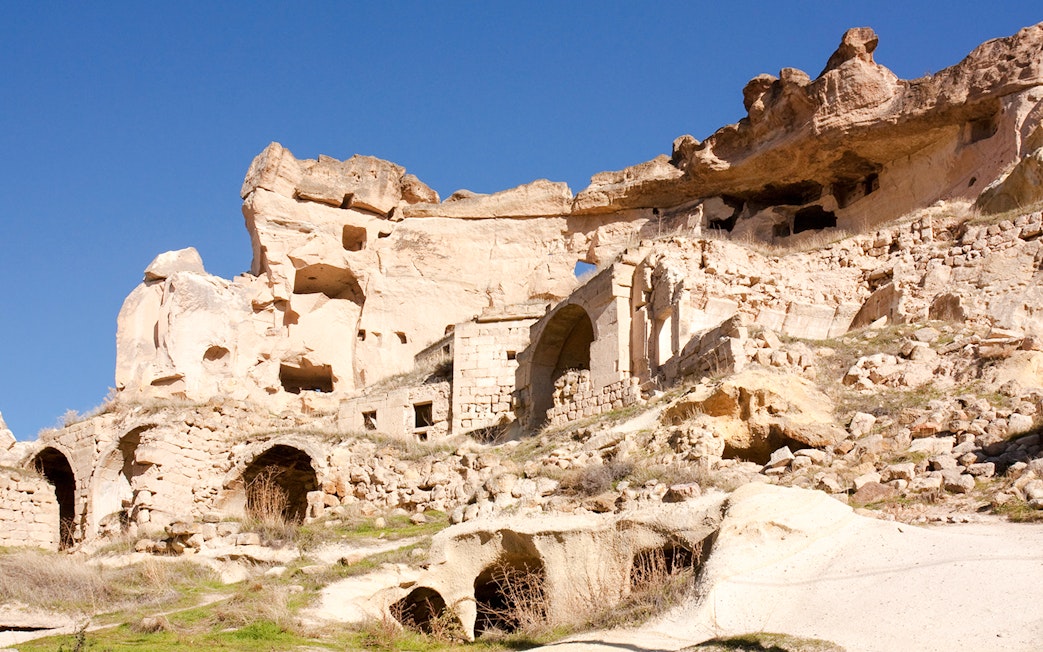 Rock formations and ancient cave dwellings in Çavuşin Village, Cappadocia.