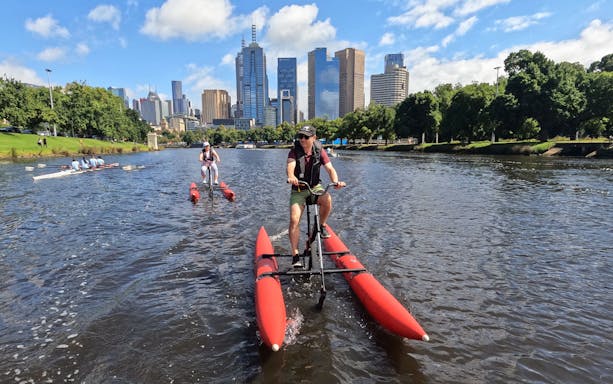 Waterbiking on Yarra River with Melbourne skyline in the background.