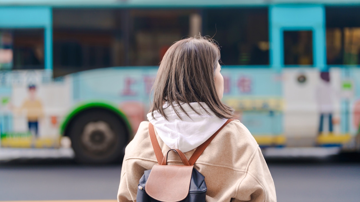Woman with backpack waiting for bus in Taiwan.
