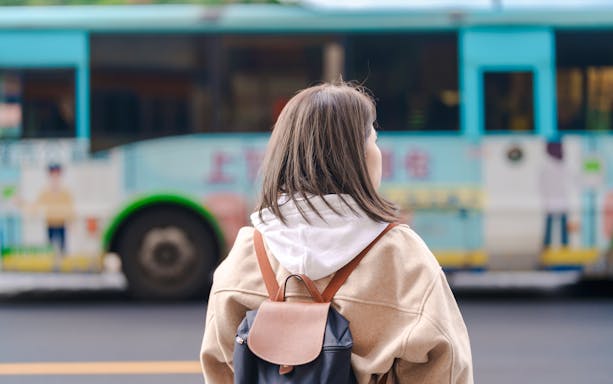 Woman with backpack waiting for bus in Taiwan.