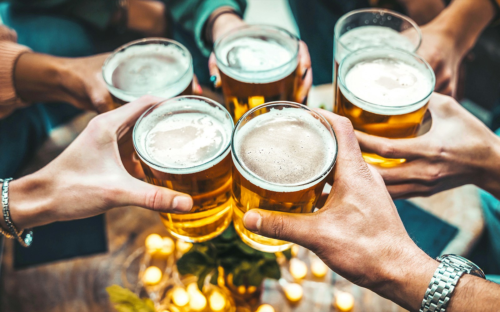 People toasting with glasses of German beer.