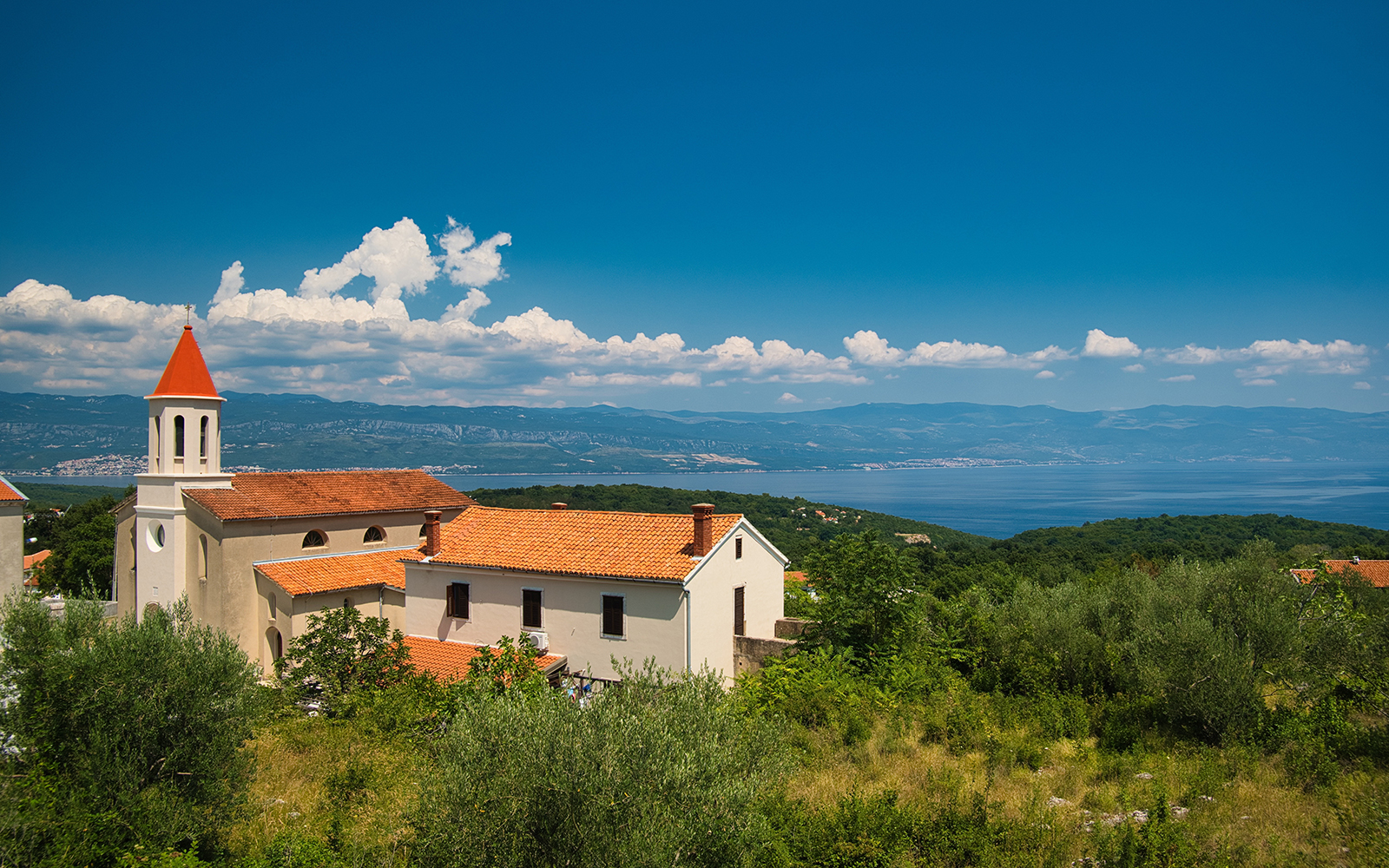 St. Jerome's Church with red roof and bell tower overlooking the Adriatic Sea in Croatia.