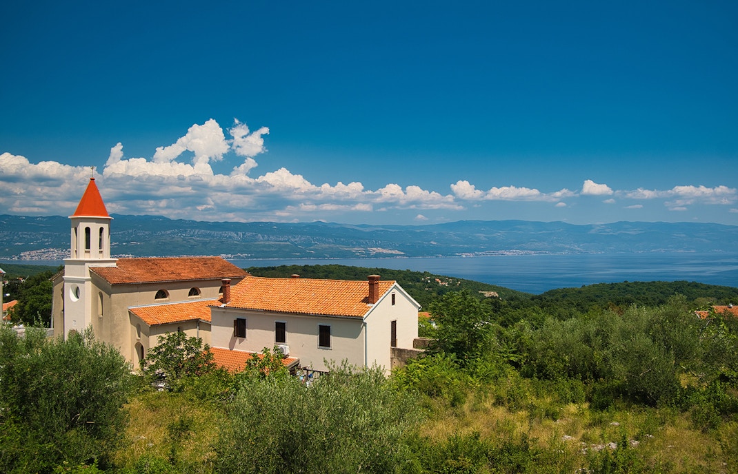 St. Jerome's Church with red roof and bell tower overlooking the Adriatic Sea in Croatia.
