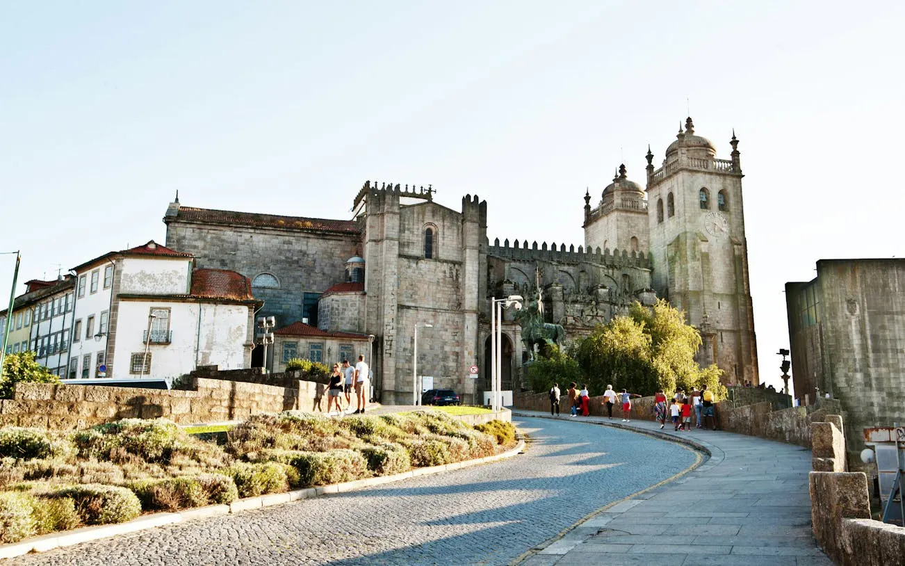 Porto Cathedral with tourists walking along the cobblestone path, part of a self-guided city exploration game.