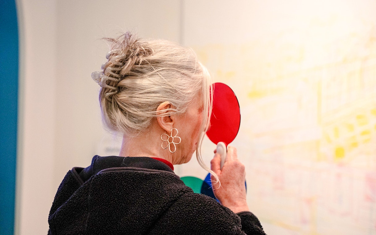 Guest exploring color illusions at World Of Illusions exhibit.