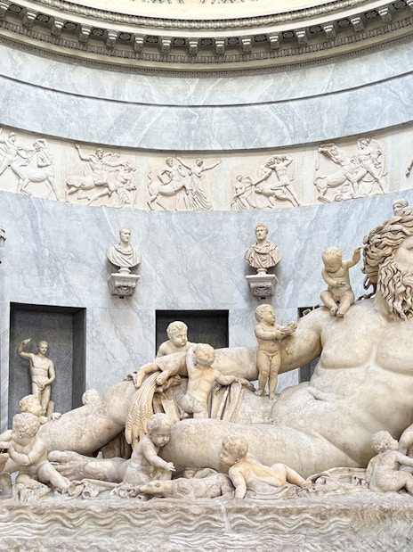 Statue of river god Oceanus surrounded by figures in Vatican Museums.