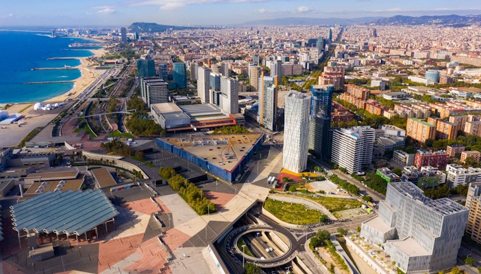 Aerial view of El Poblenou district in Barcelona with modern buildings and coastline.