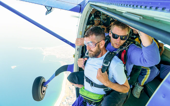 Skydiver and instructor at plane door ready to jump over Wollongong, Sydney.