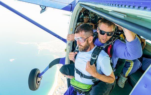 Skydiver and instructor at plane door ready to jump over Wollongong, Sydney.